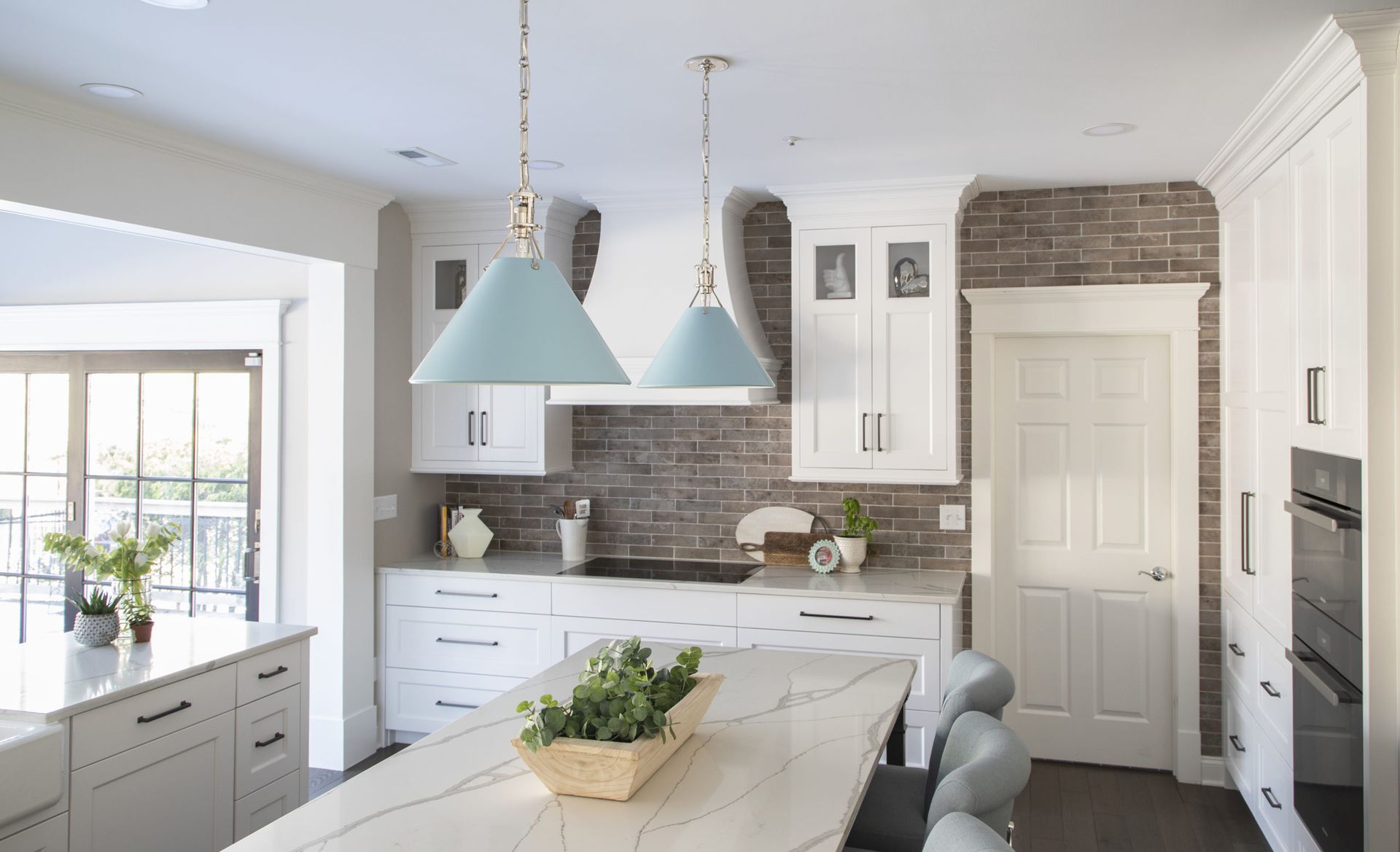 A kitchen with white cabinets and a marble counter top.