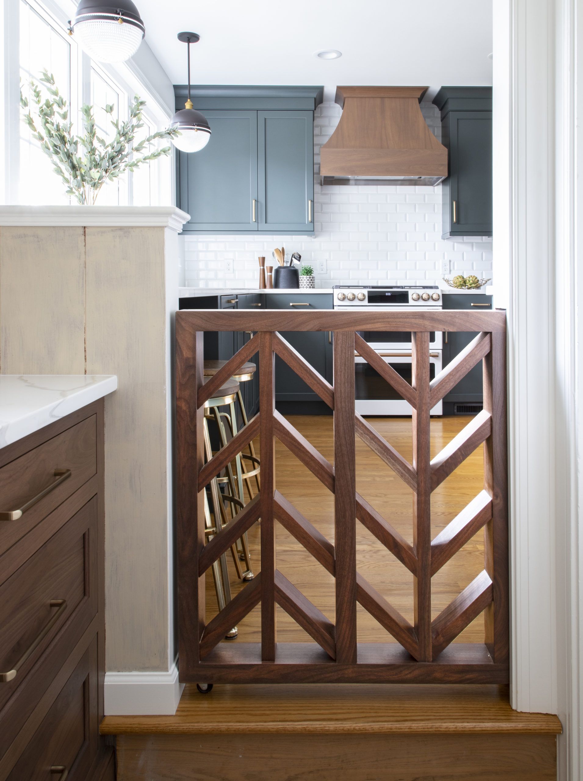A wooden gate between a kitchen and stairs