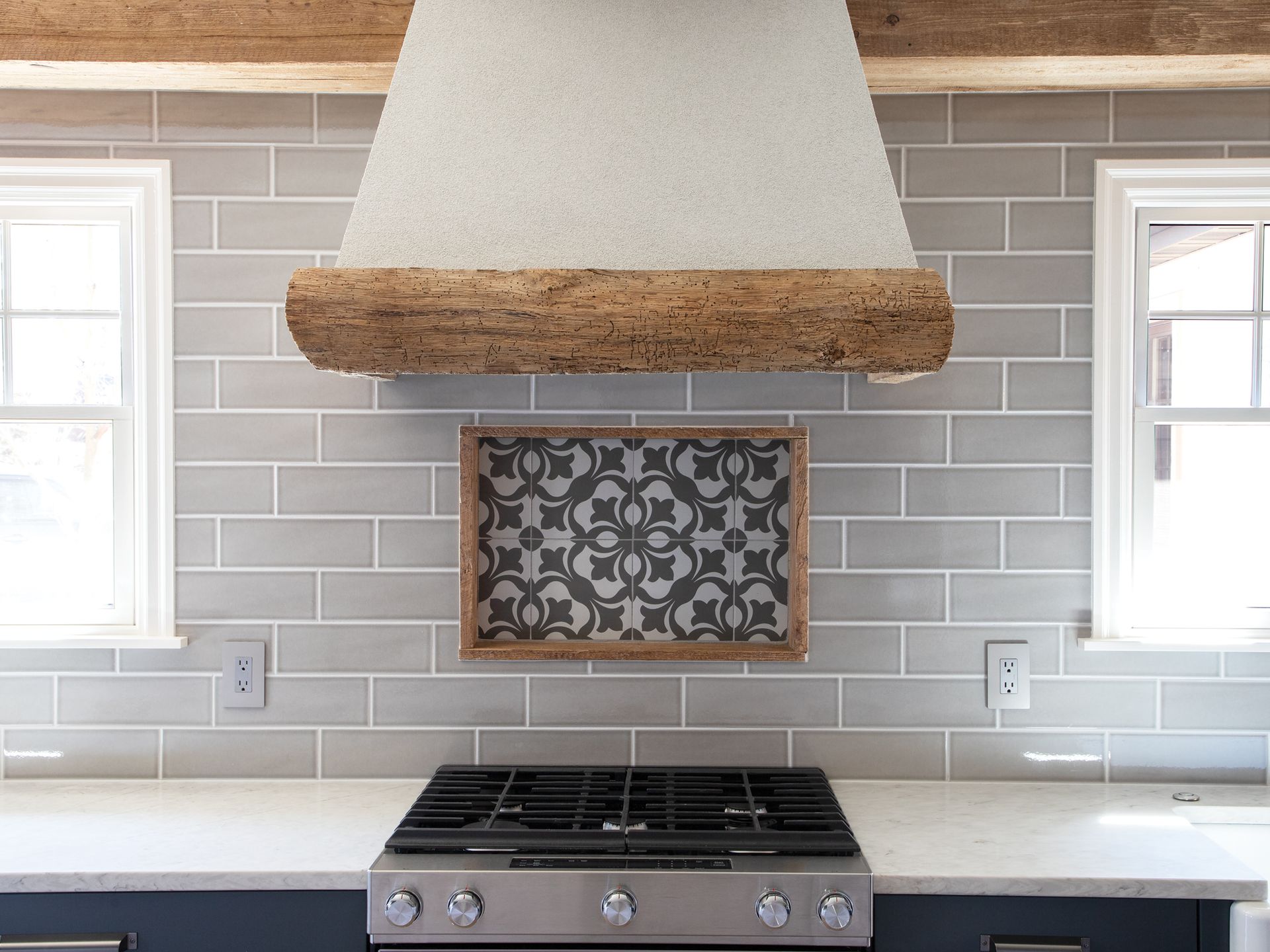 A kitchen with a stove top oven and a hood above it.