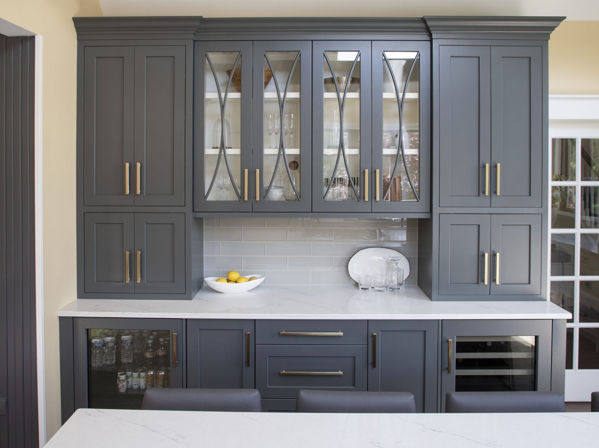 A kitchen with gray cabinets and a white counter top.