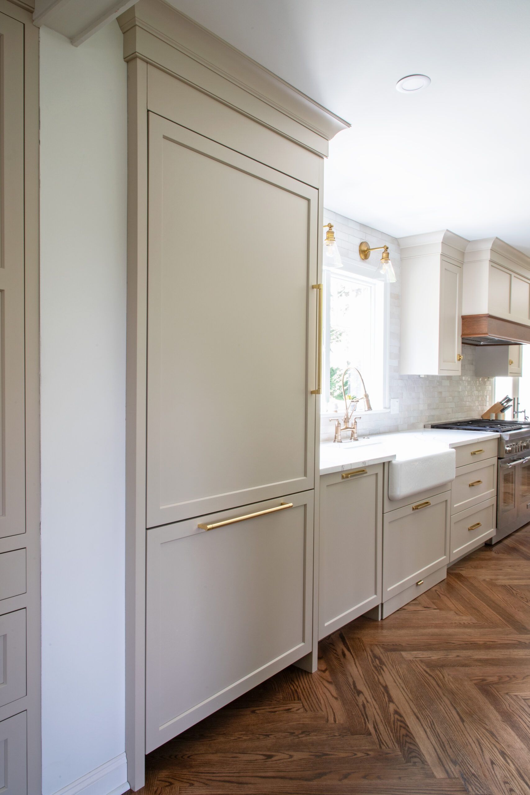 A kitchen with white cabinets , a sink , and a refrigerator.