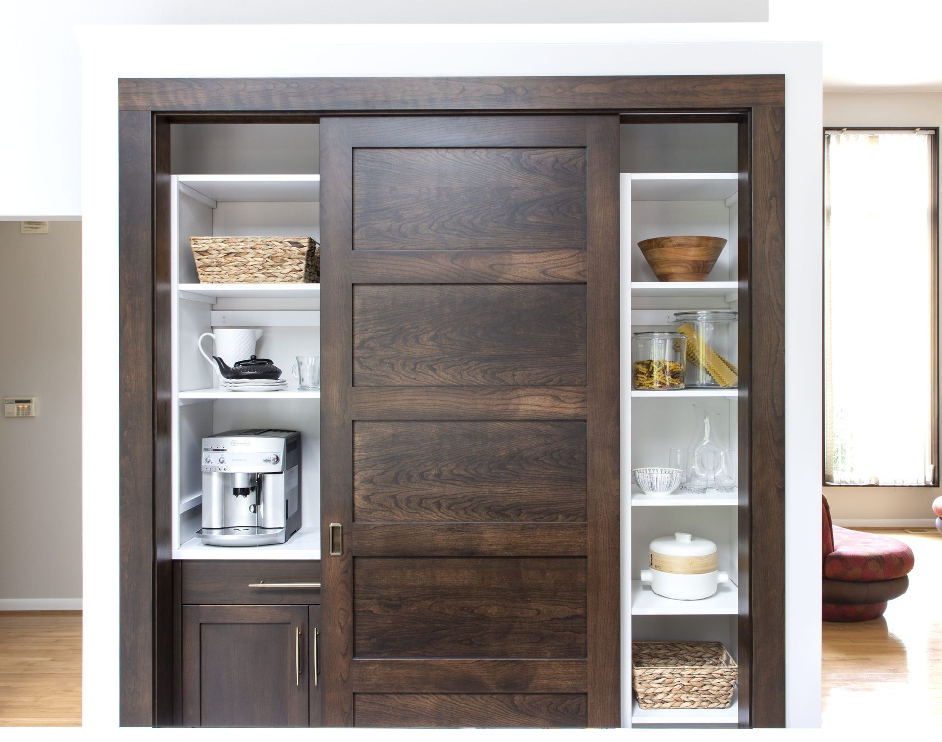 A kitchen with a sliding door and a coffee maker