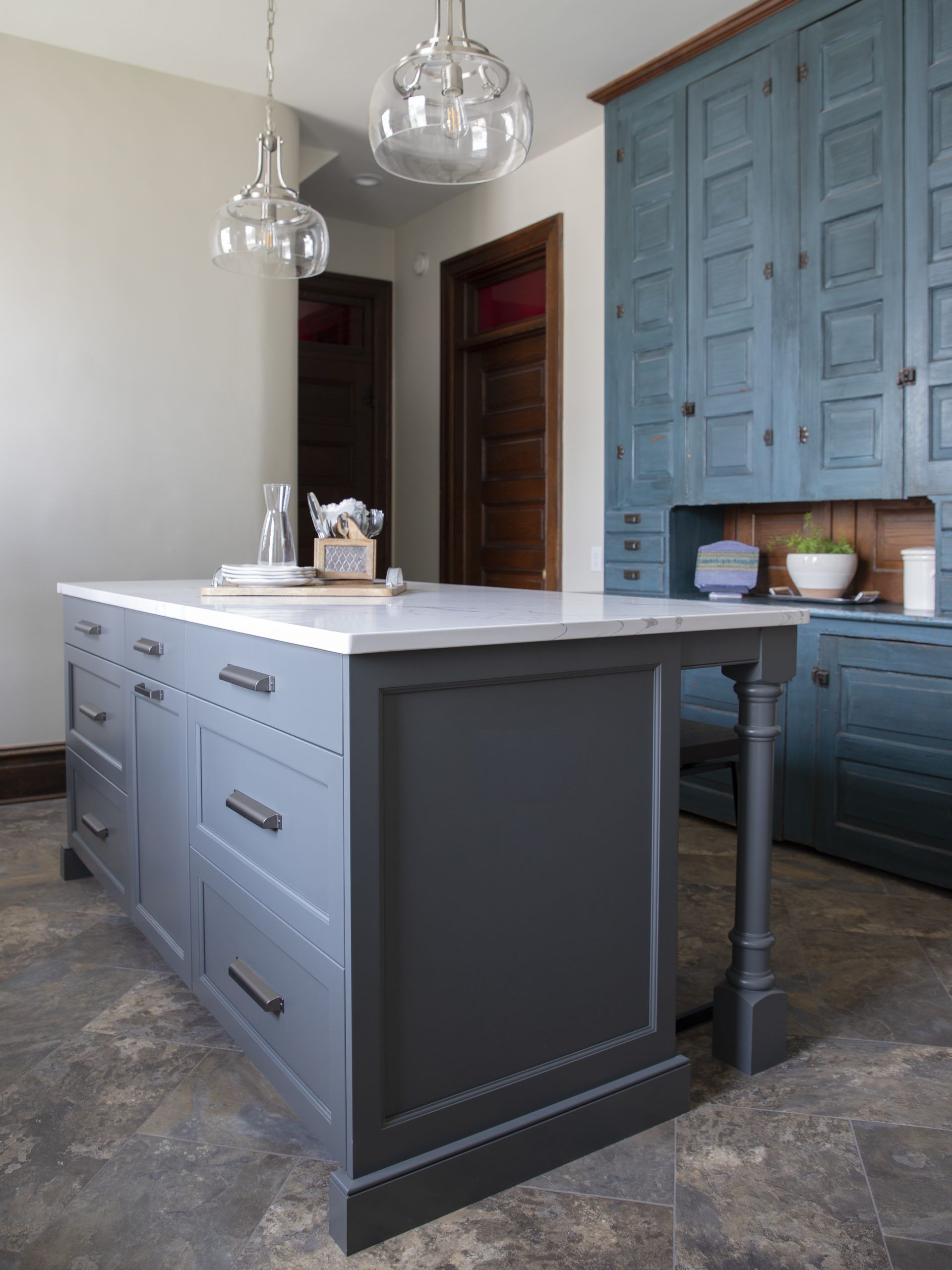 A kitchen with a large island and blue cabinets