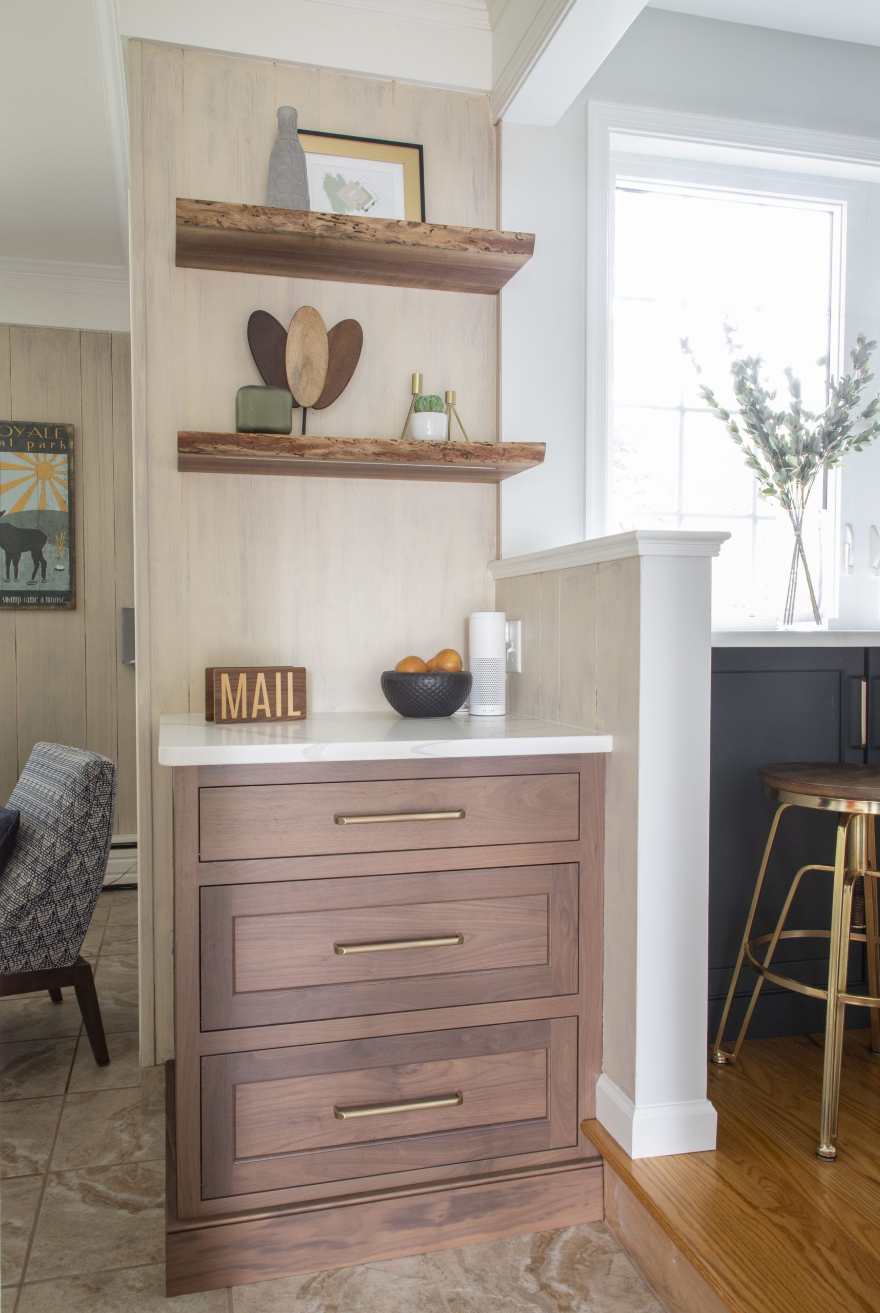 A wooden dresser with drawers and shelves in a kitchen next to a window.