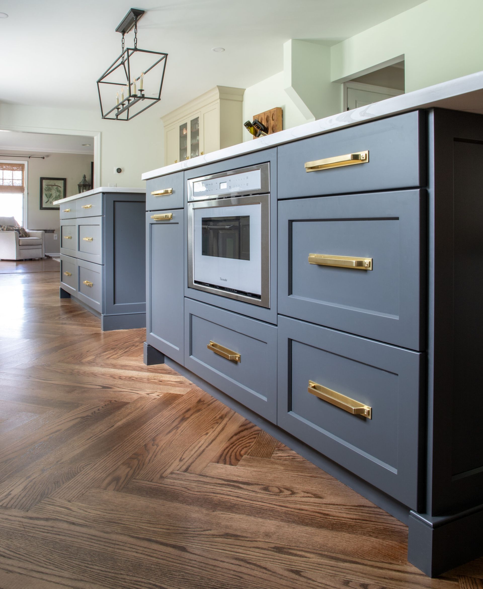A kitchen with gray cabinets and gold handles