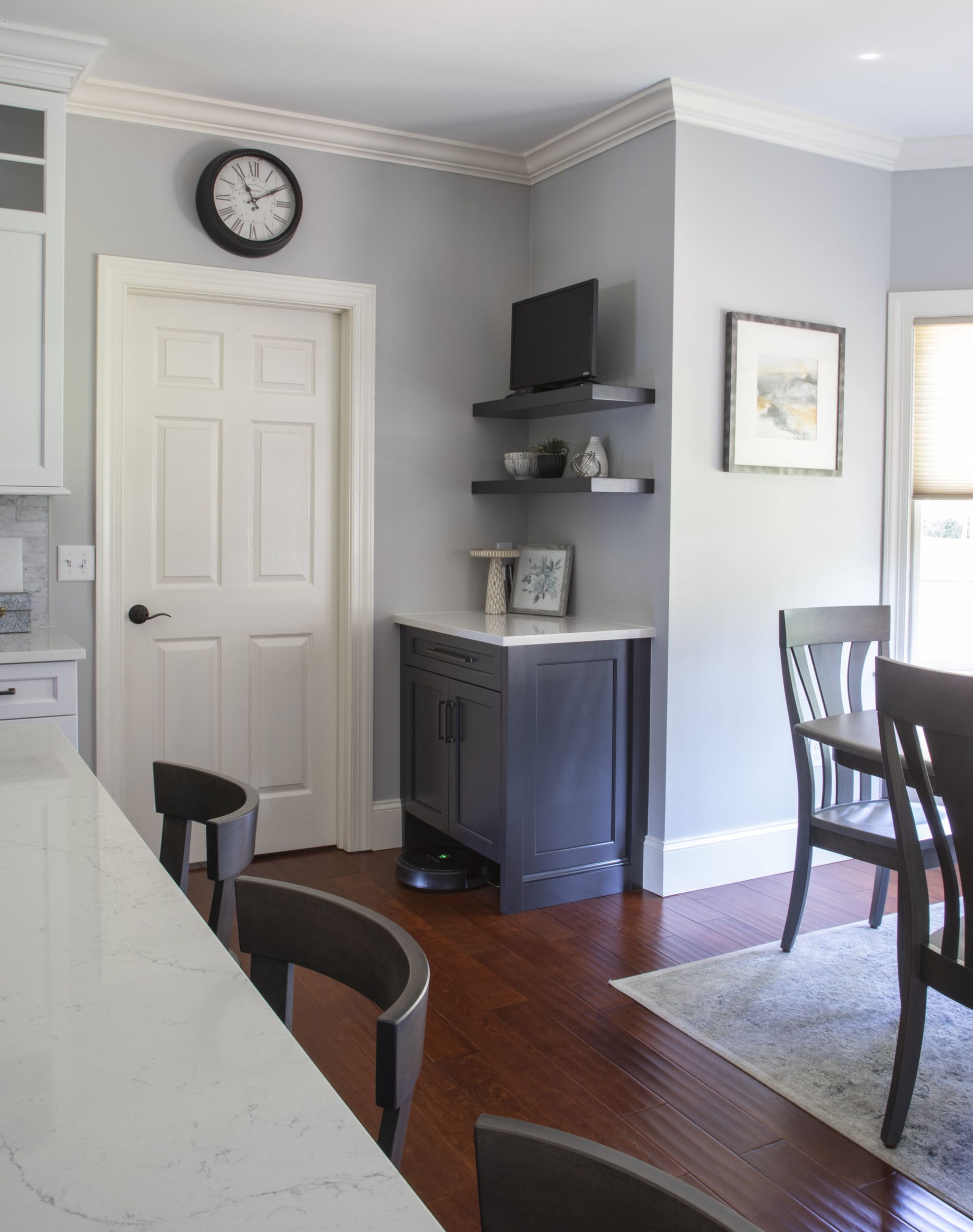 A kitchen with a clock on the wall above the door