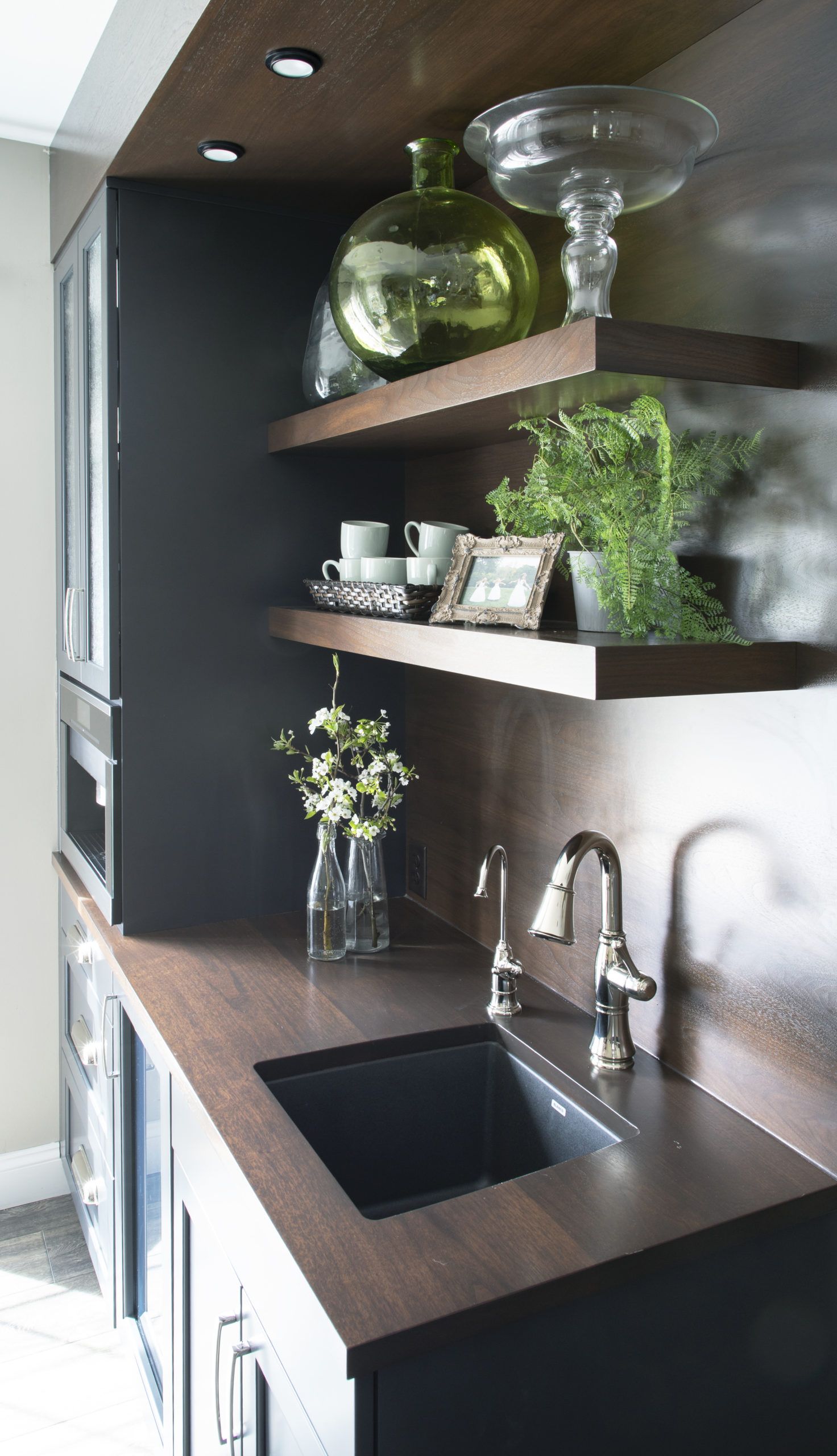 A kitchen with a sink and a vase of flowers on the counter.