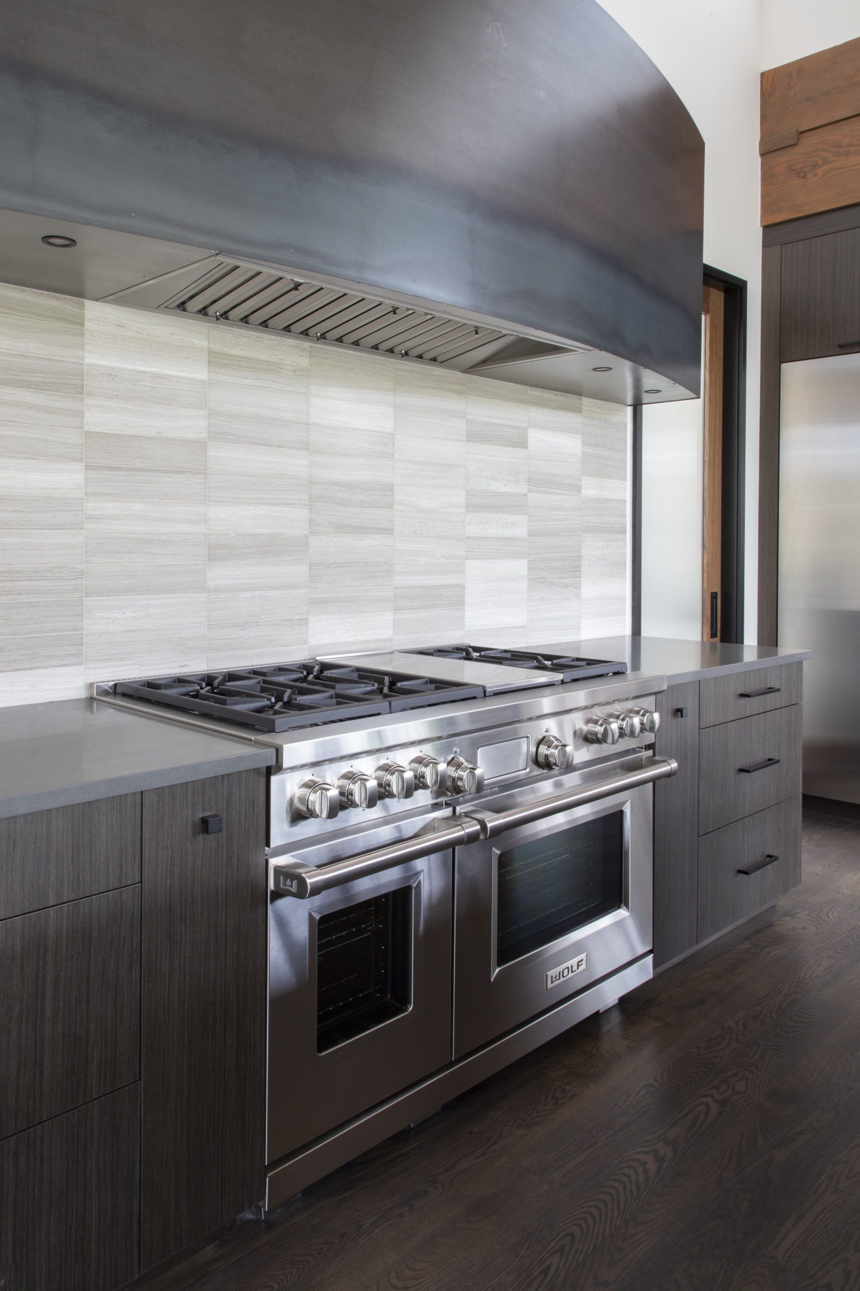 A kitchen with a stove top oven and a hood.