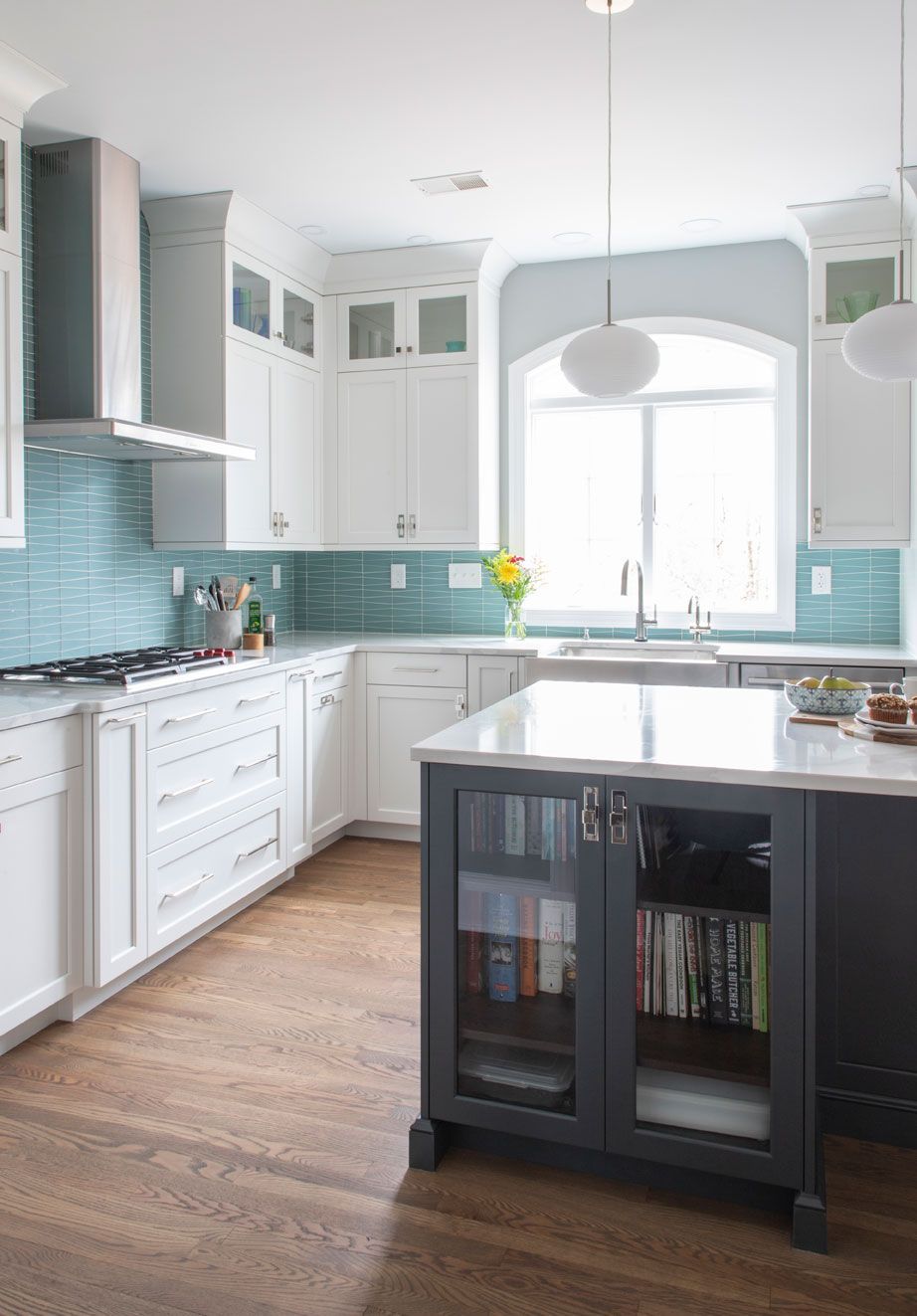 A kitchen with white cabinets and a large island in the middle.