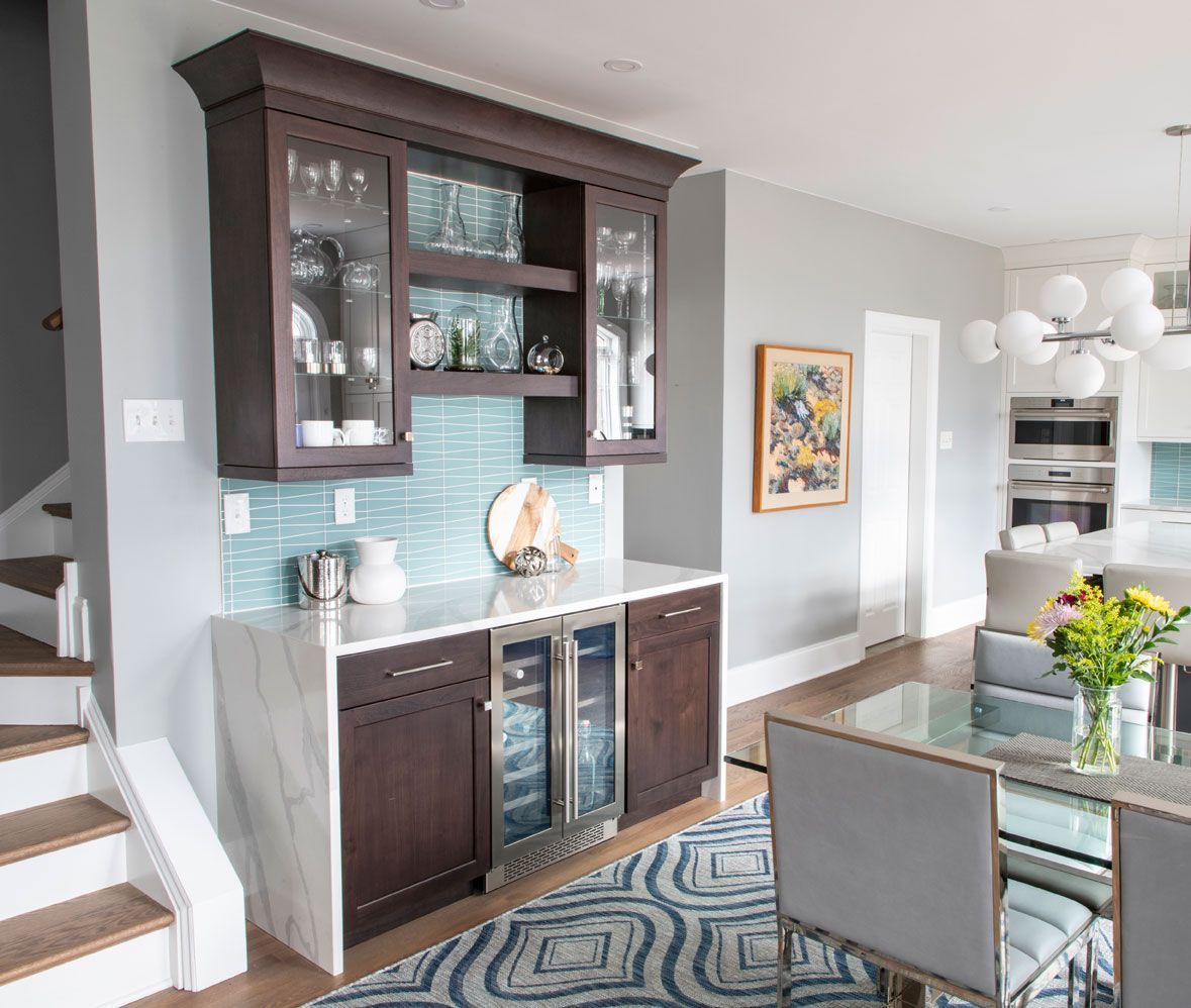 A living room with a dining room table and chairs and a bar.