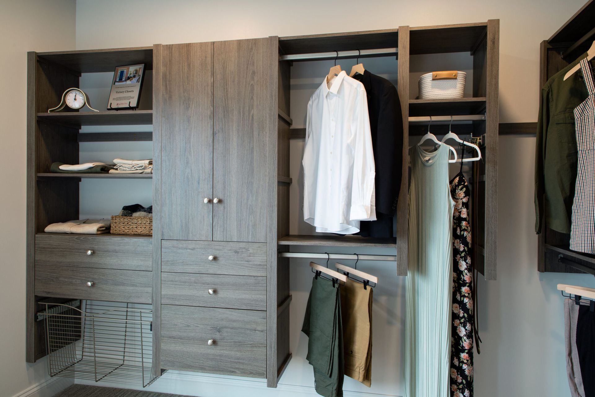 A walk in closet with clothes hanging on racks and shelves.