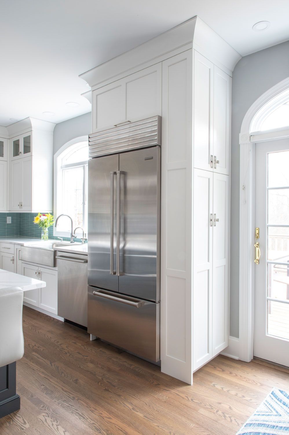 A kitchen with stainless steel appliances and white cabinets.