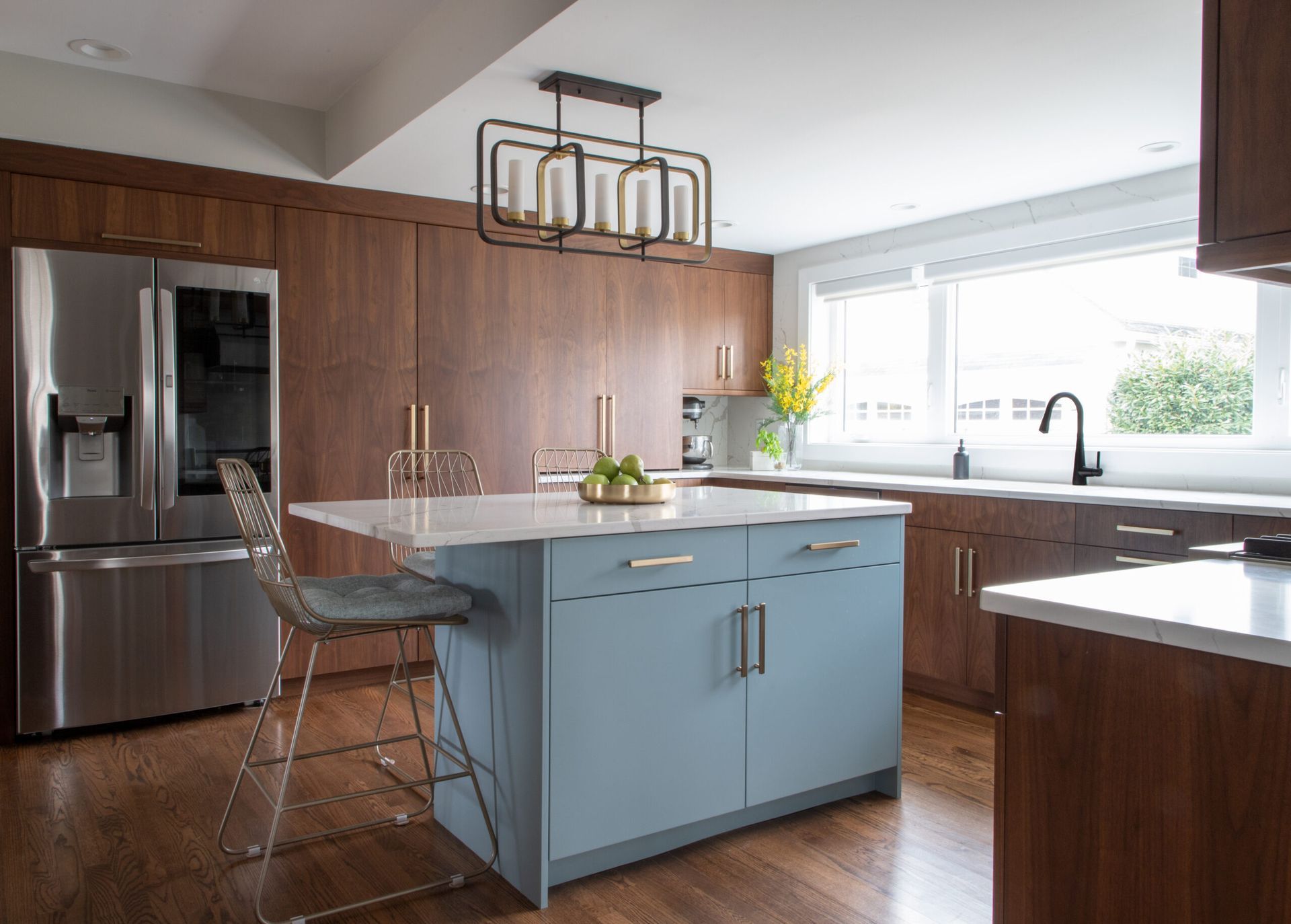A kitchen with a large island , stainless steel appliances , wooden cabinets and a stainless steel refrigerator.