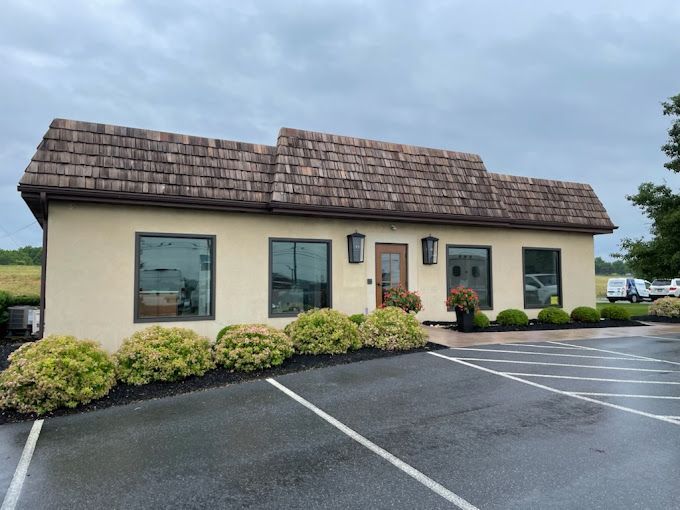 A building with a lot of windows and a parking lot in front of it