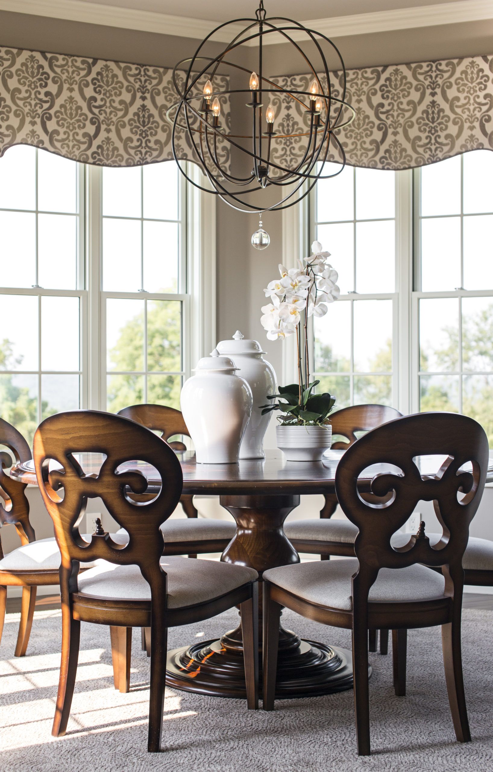 A dining room with a table and chairs and a chandelier.