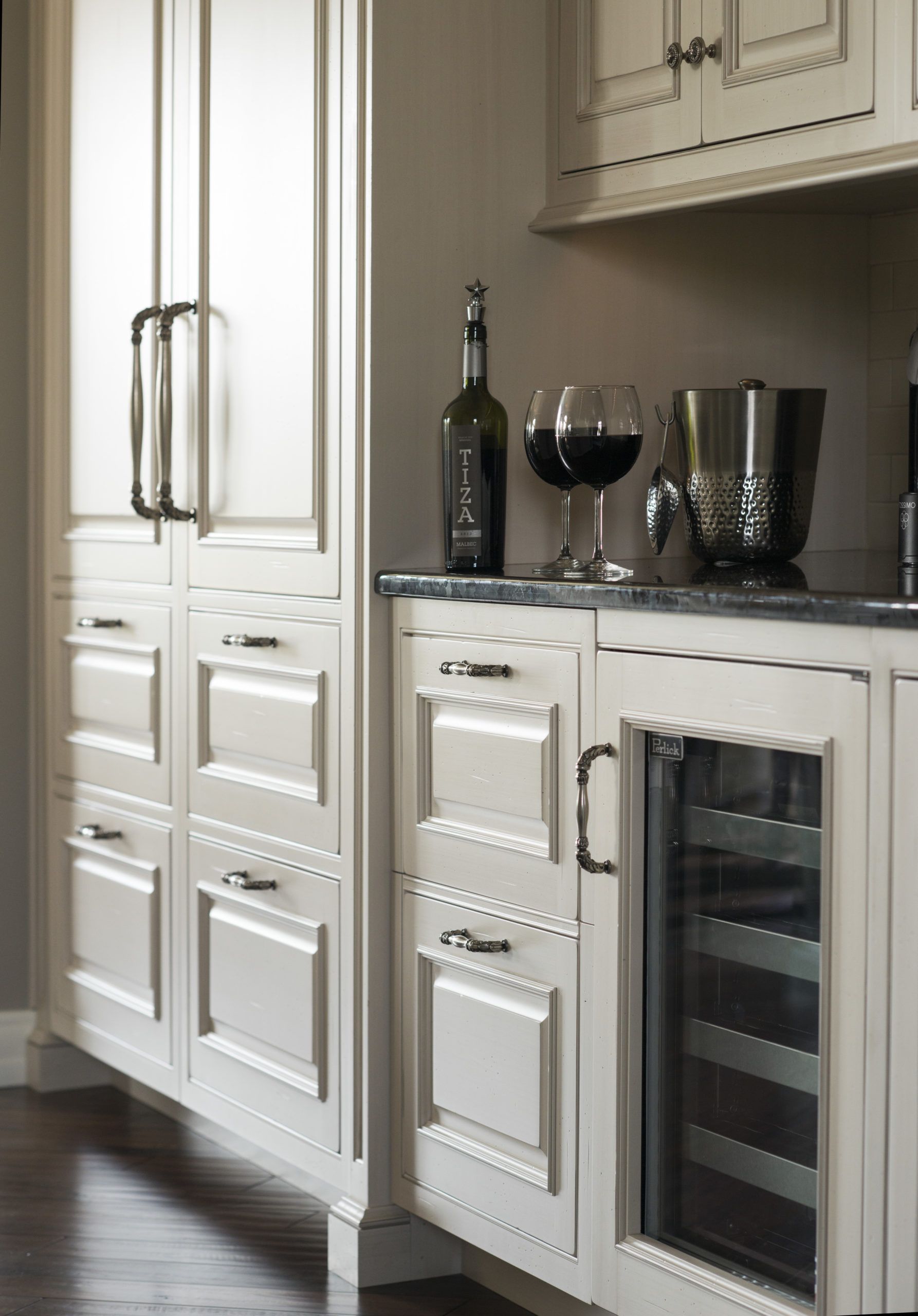 A kitchen with white cabinets and a wine cooler