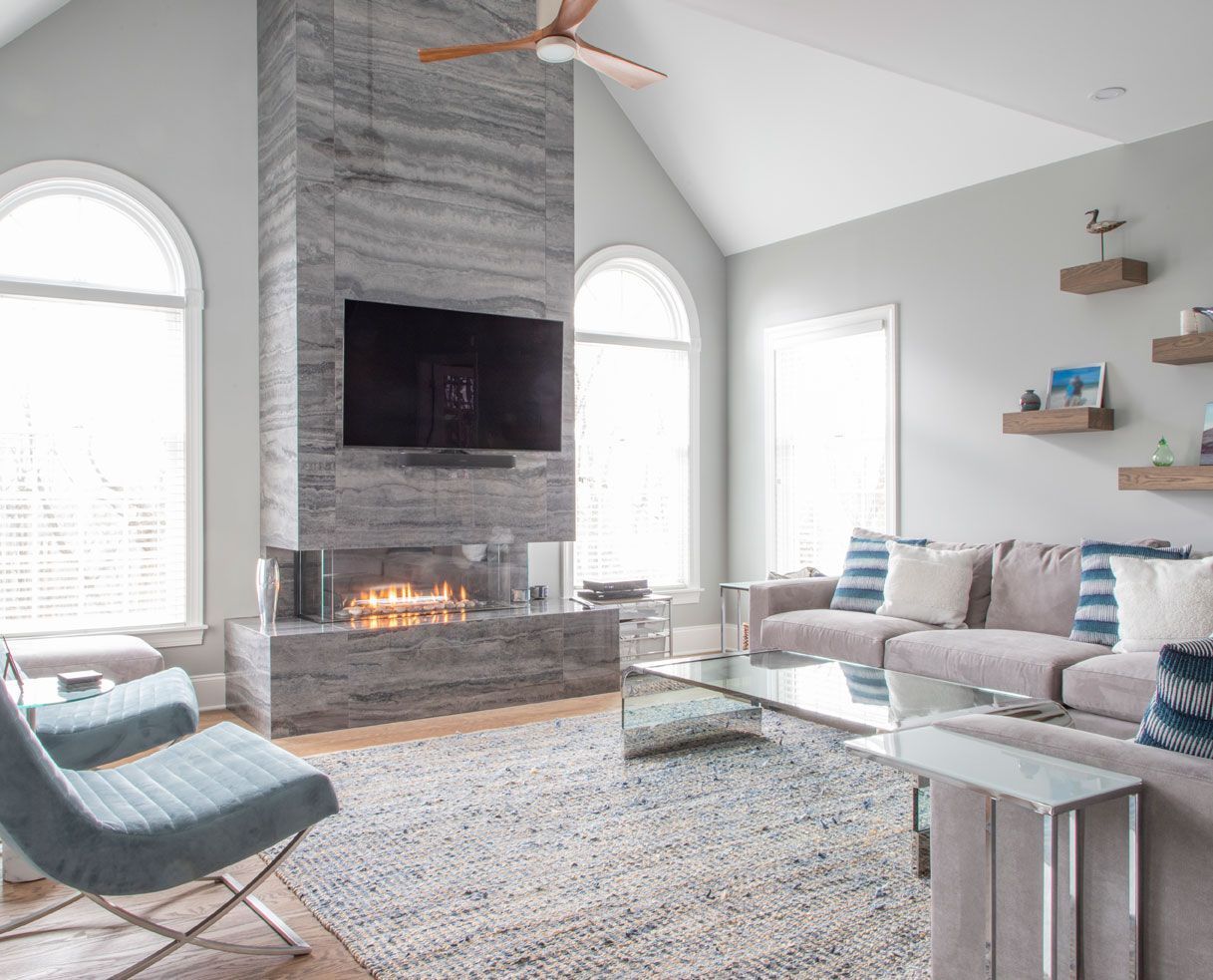 A living room with a fireplace , couch , chair and television.