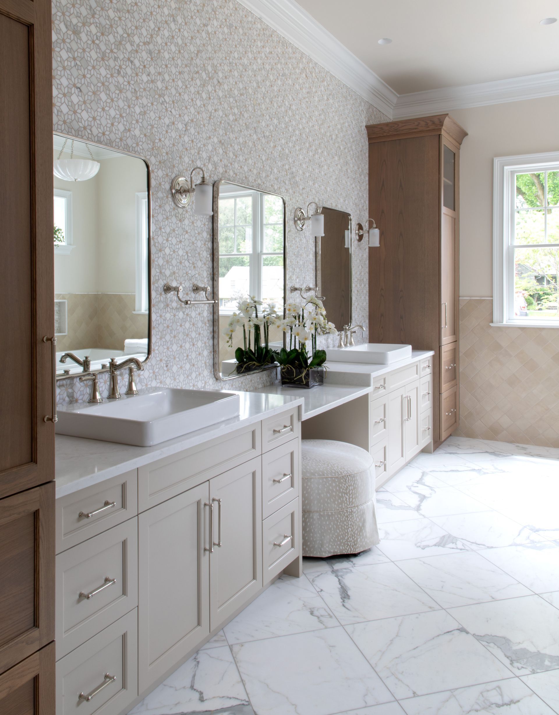 Elegant, neutral-toned bathroom with marble floors, double vanity, and a textured wall.