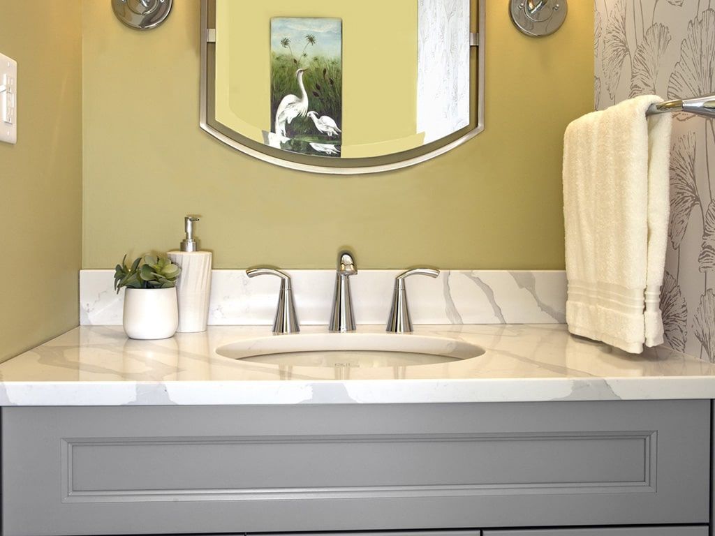 A bathroom with a sink , mirror and towel rack.