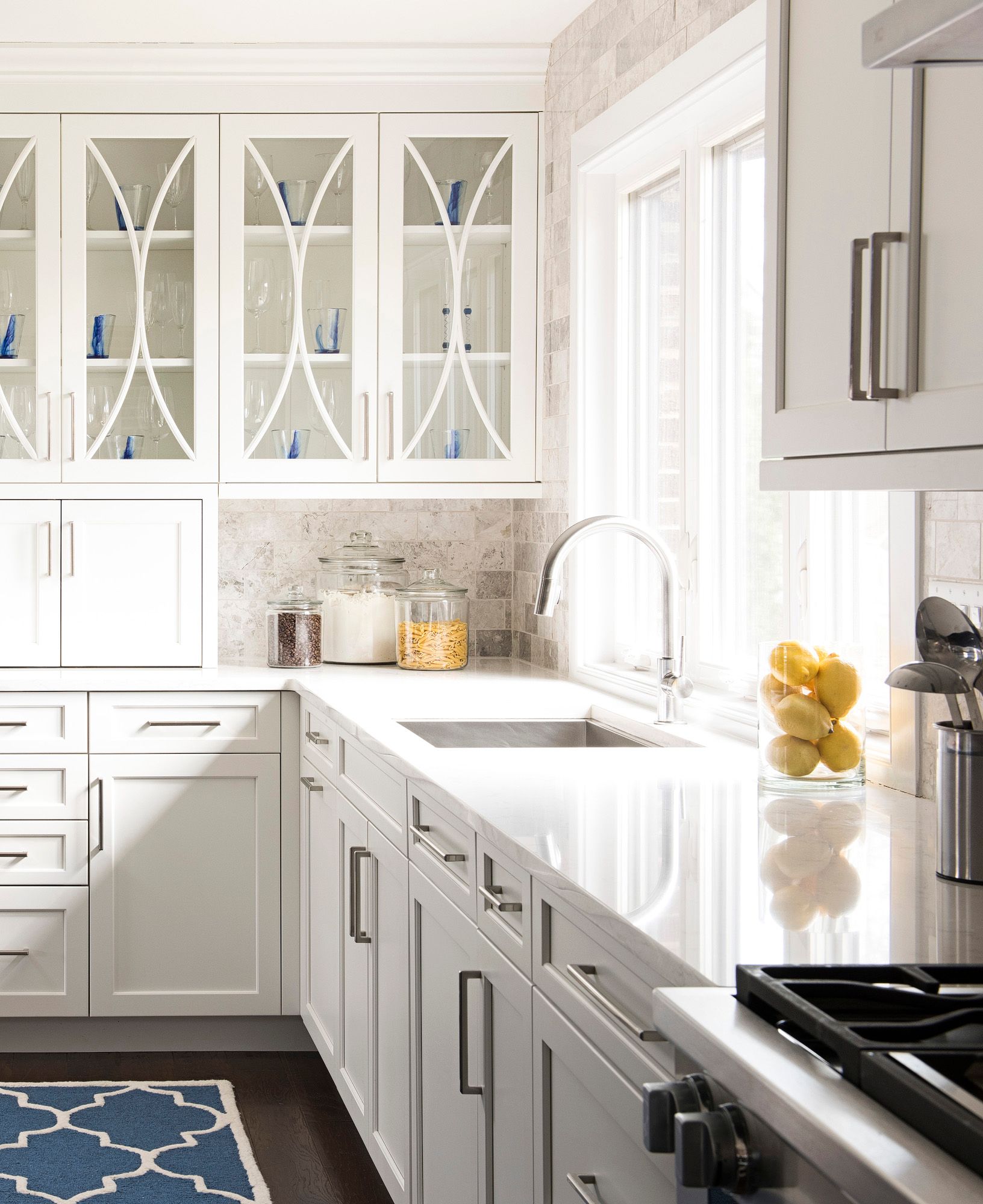A kitchen with white cabinets and a stove top oven