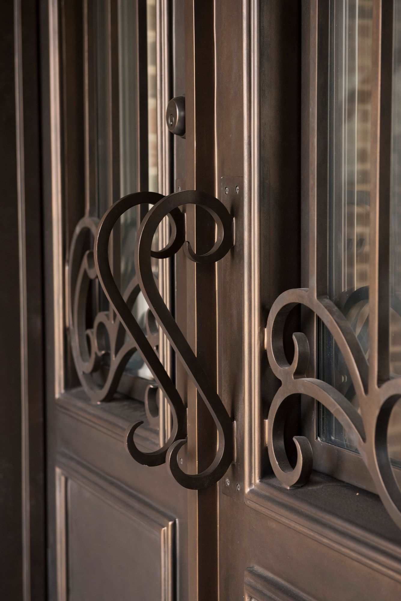 A close up of a door with a wrought iron handle