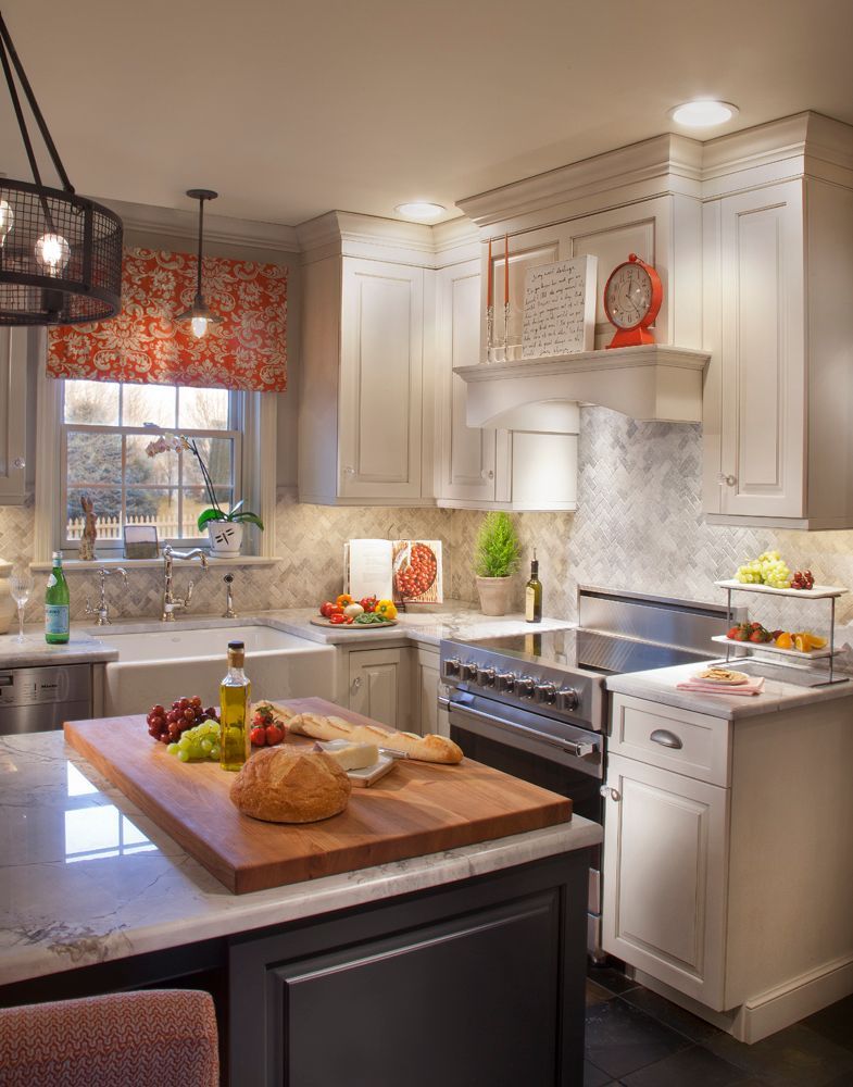 A kitchen with white cabinets and a wooden cutting board