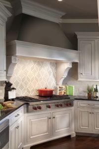 A kitchen with white cabinets and a stove top oven