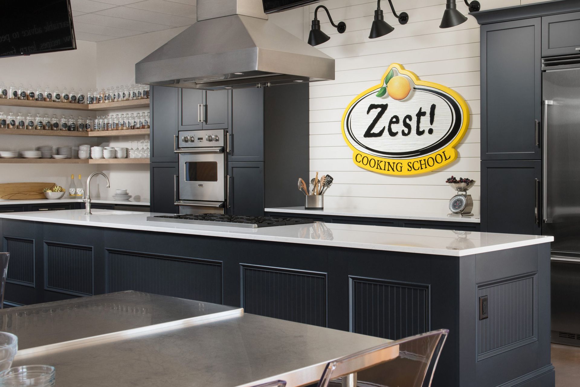A kitchen with a zest cooking school sign on the wall.