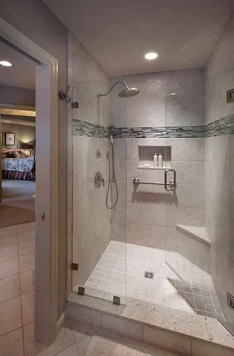 A bathroom with a walk in shower with a glass door.