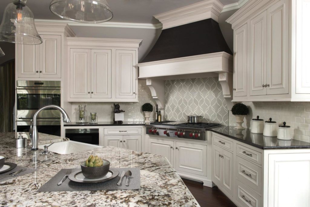 A kitchen with white cabinets and granite counter tops