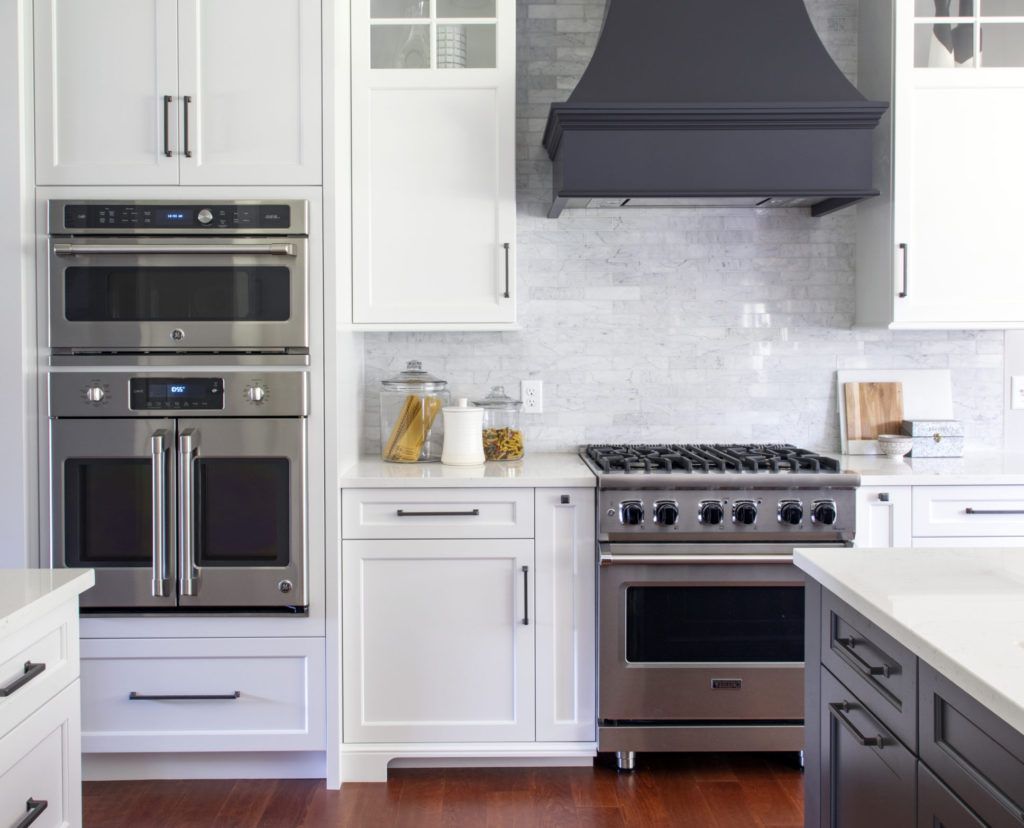 Stainless steel ovens, a range hood, and kitchen cabinets