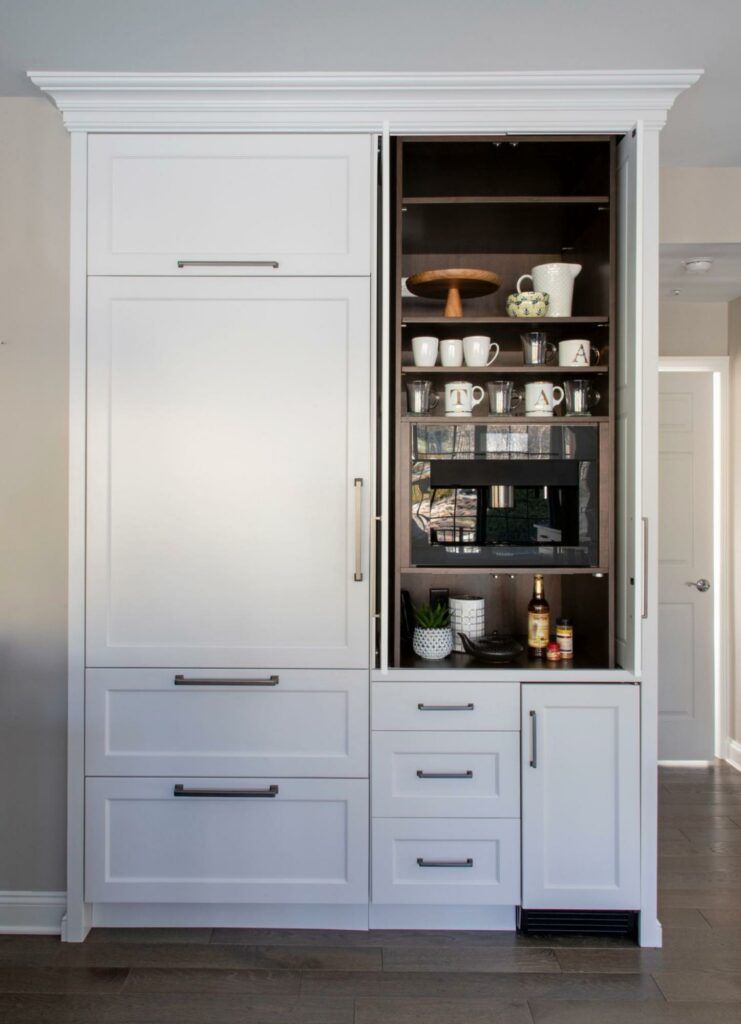 A white cabinet with drawers and a microwave inside of it.