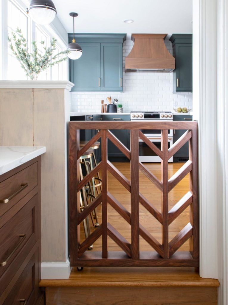 A wooden gate is between a kitchen and a hallway.