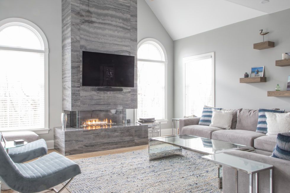 A living room with a fireplace , couch , chair and television.