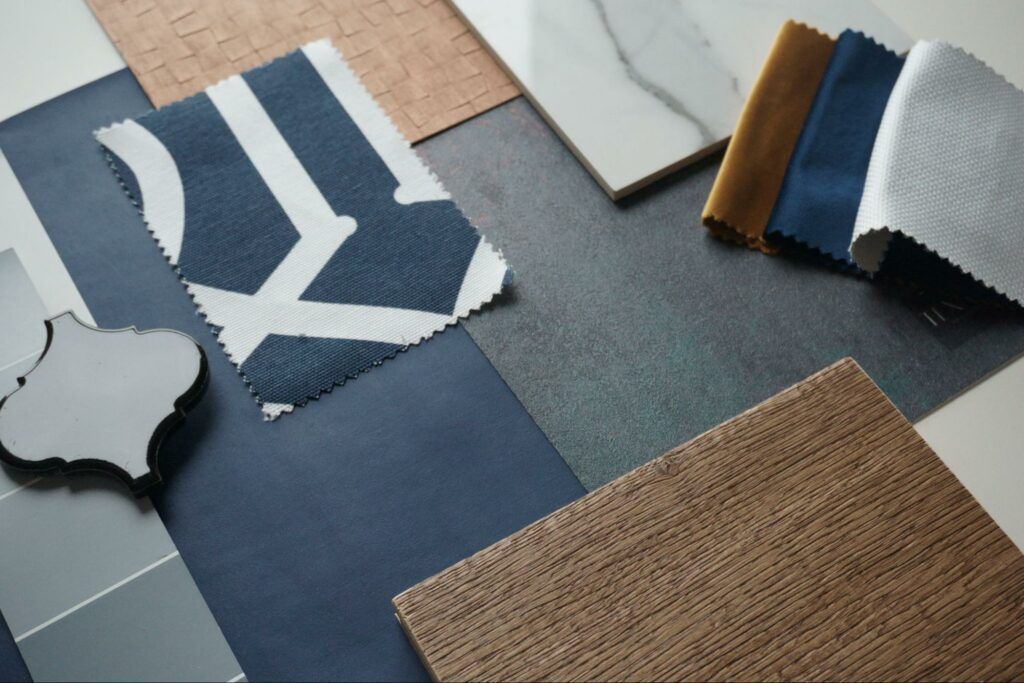 A variety of fabrics and tiles are laid out on a table.