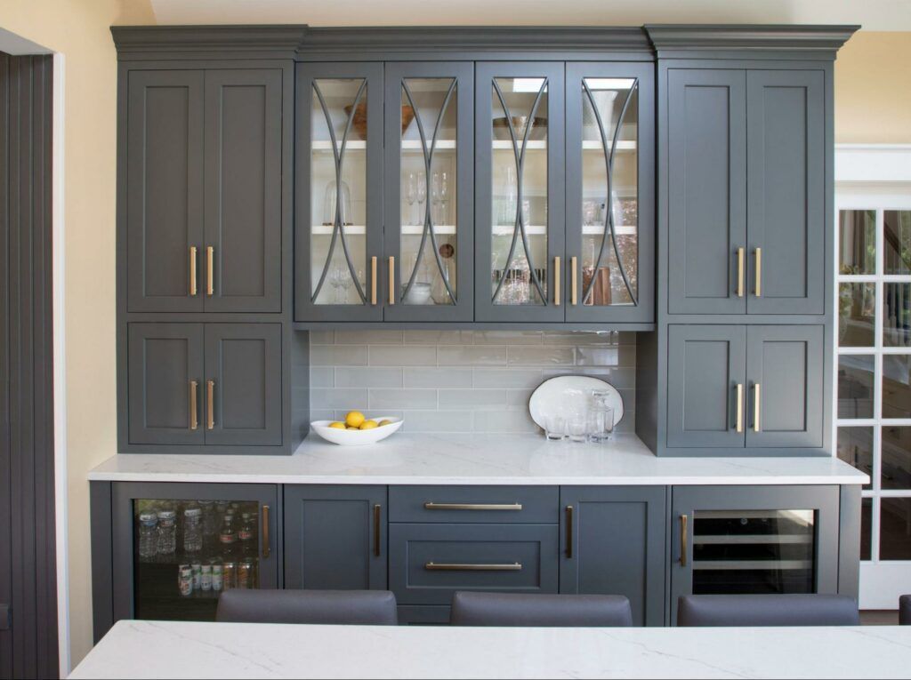 A kitchen with gray cabinets and a white counter top.