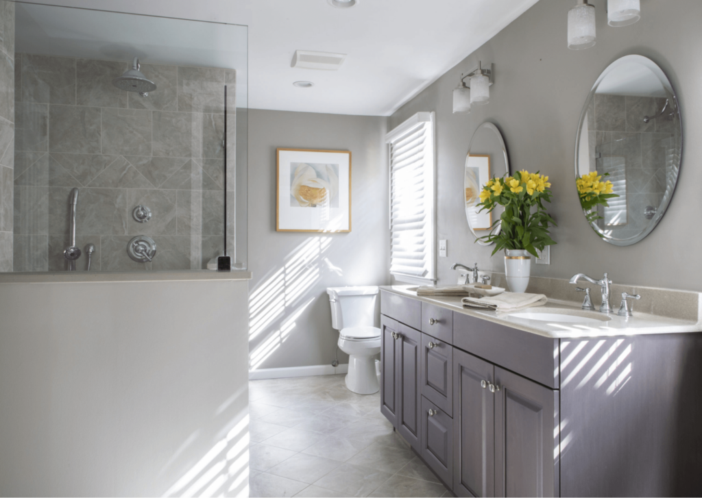 A bathroom with two sinks , a toilet and a shower.