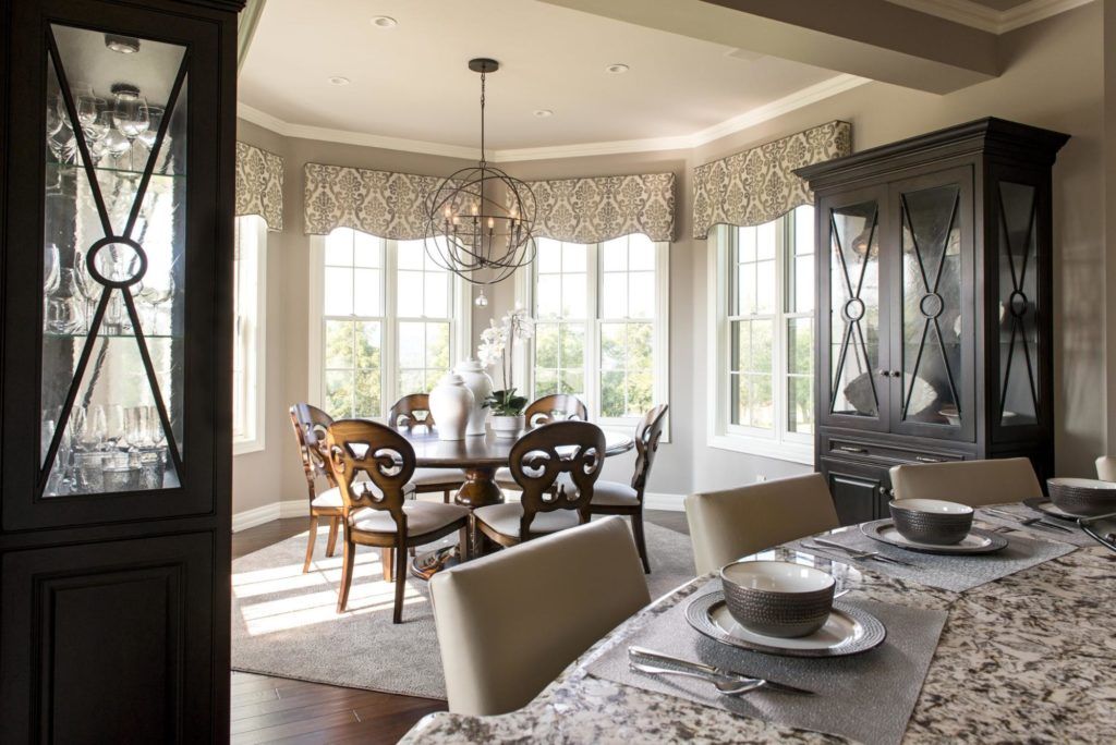 A dining room with a table and chairs and a hutch.