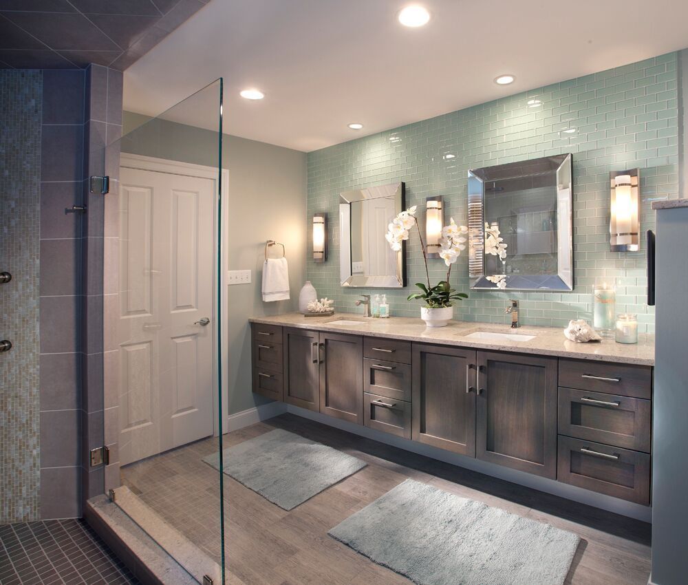 A bathroom with two sinks and a walk in shower