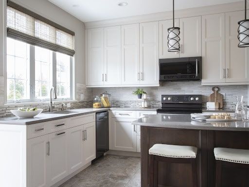 A kitchen with white cabinets , a stove , a microwave , a sink , and a large island.