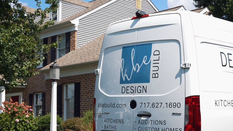 White work van with “Build” logo parked beside a house in a residential driveway.