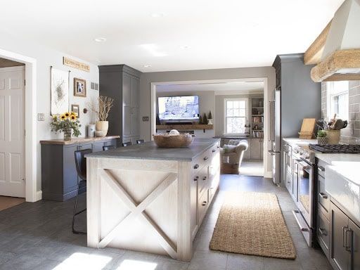 A kitchen with a large island and a flat screen tv