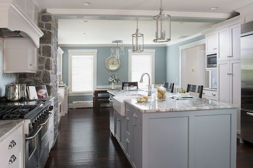 A kitchen with a large island in the middle and a stove.