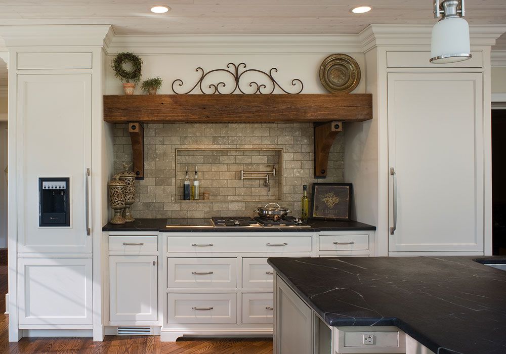 A kitchen with white cabinets and a black counter top