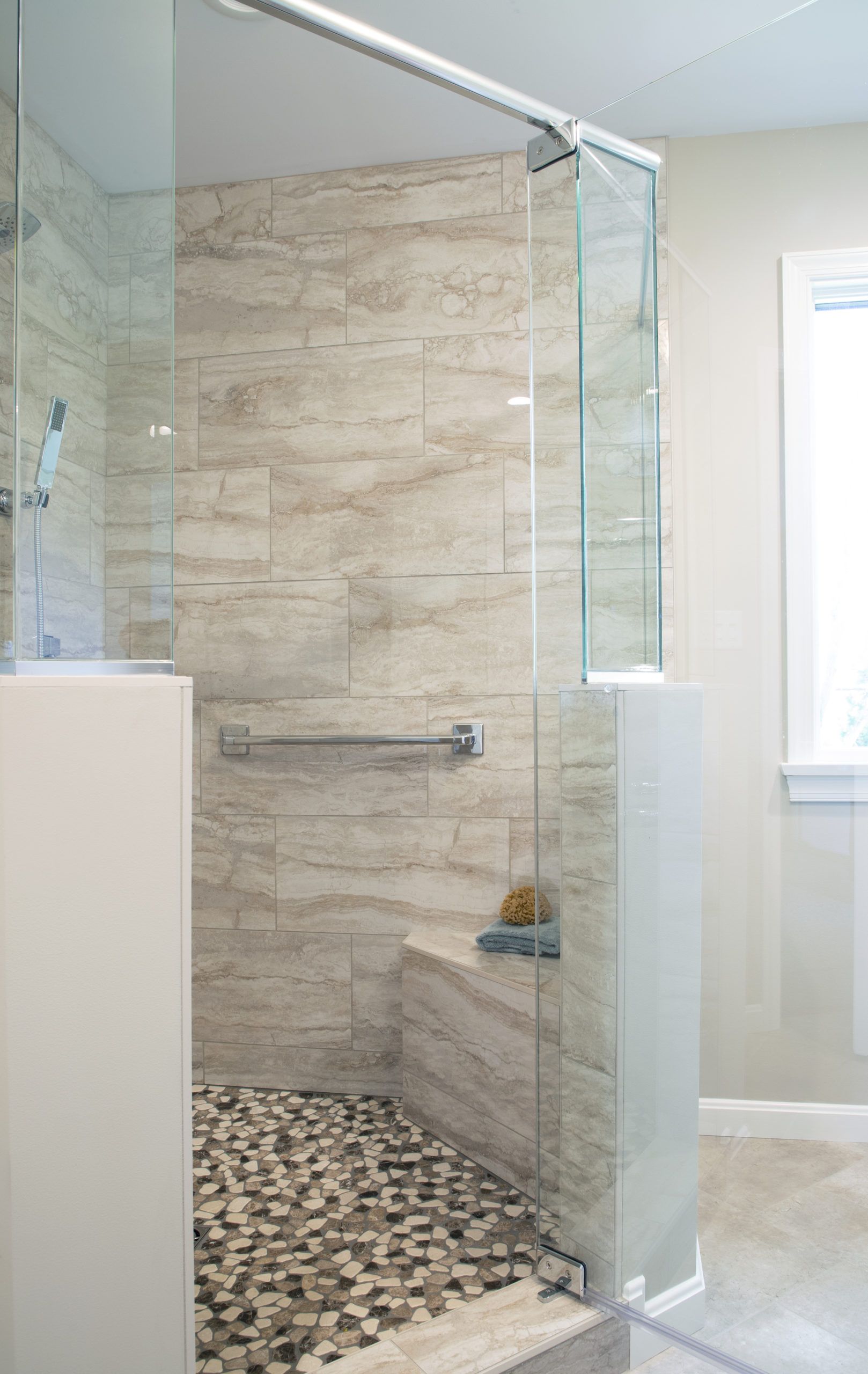 An ADA complaint bathroom with a walk in shower with a glass door.