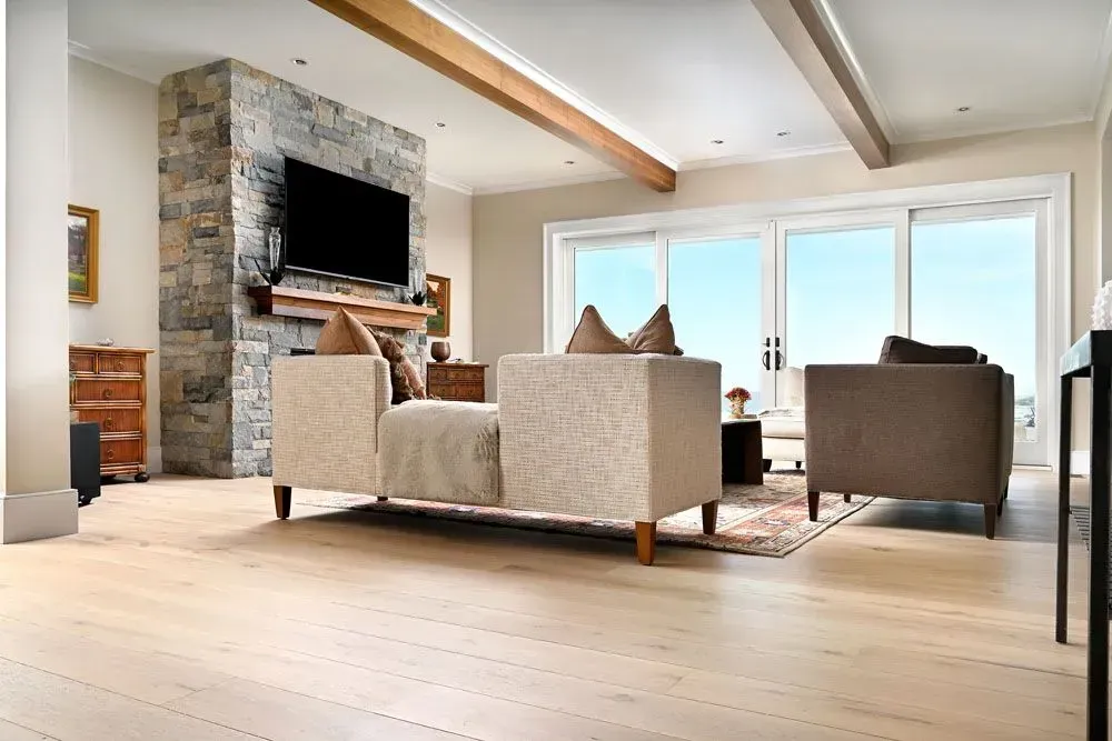 Living room with stone fireplace, light-colored sofa, and sliding glass doors with a view.
