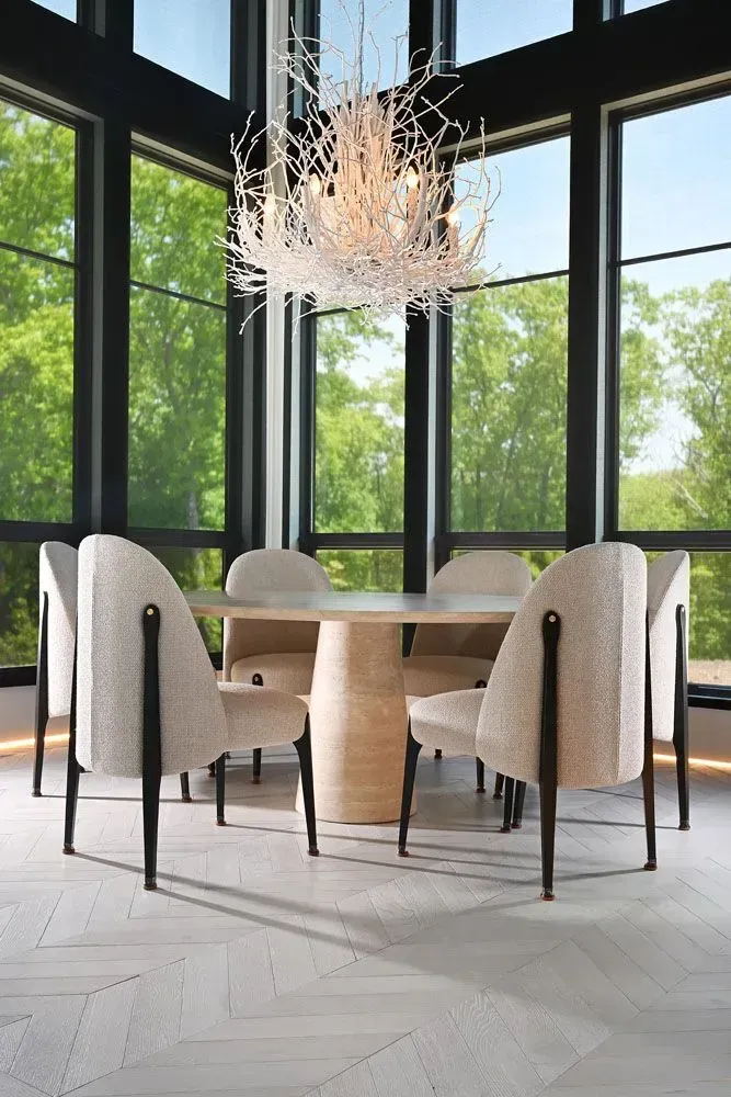 Dining room with modern table and chairs, large windows, and a decorative chandelier.