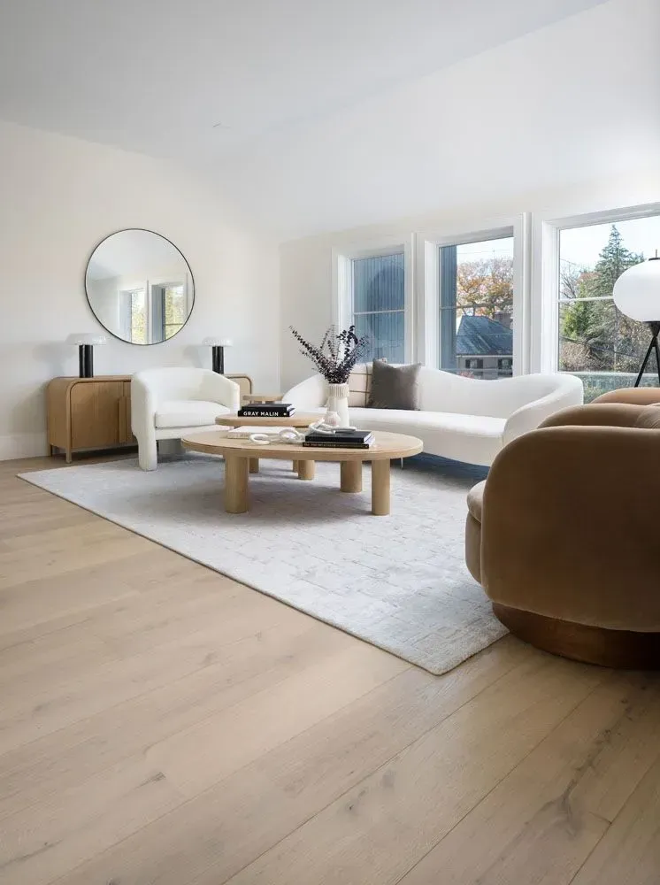 Living room with white walls, light wood floors, and a neutral color palette.