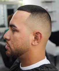 A man with a beard is getting his hair cut at a barber shop.