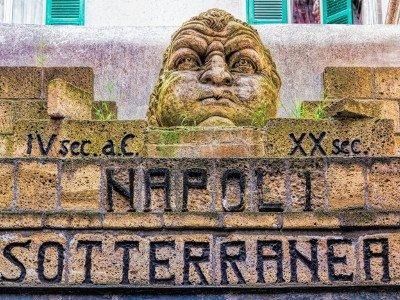 Una testa di pietra si trova in cima a un muro con la scritta
